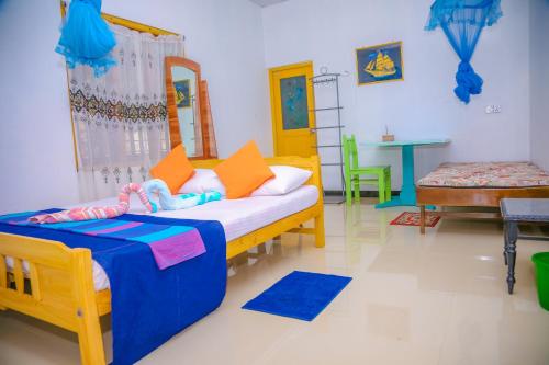 a room with a bed and a table in it at Oceanic White House in Nilaveli