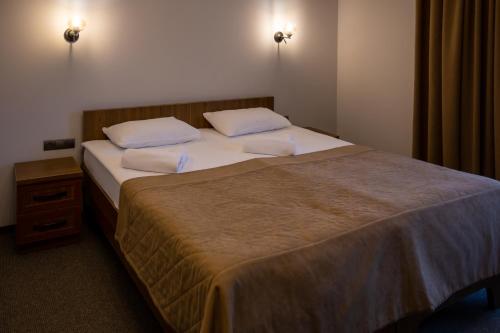 a bedroom with a large bed with white sheets and pillows at Князів Двір in Bukovel
