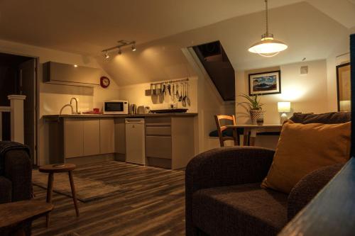a living room with a couch and a kitchen at The Walk-up in Portree
