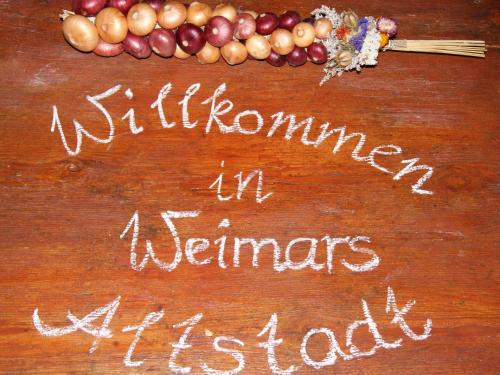 a sign on a table with a bunch of vegetables at Altstadt-Ferienwohnung in Weimar