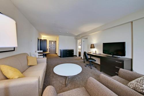a living room with a couch and a tv at Coast Kamloops Hotel & Conference Centre in Kamloops