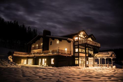 a building with lights on in the snow at night at MountainLodge am Ötscher in Lackenhof