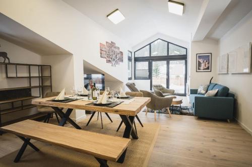 a dining room and living room with a table and chairs at MountainLodge am Ötscher in Lackenhof