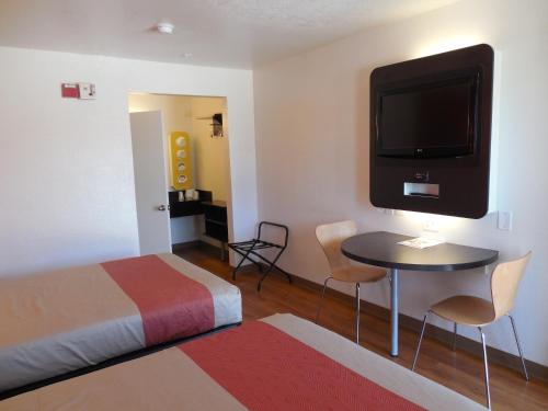 a hotel room with a bed and a tv on the wall at Motel 6-Chula Vista, CA - San Diego in Chula Vista