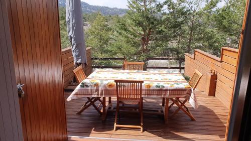 einen Tisch und Stühle auf der Terrasse eines Hauses in der Unterkunft Studio avec cheminée et jardin in Gréolières