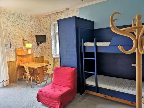 a bedroom with a bunk bed with a table and a tableablish at Delizioso monolocale in Dobbiaco