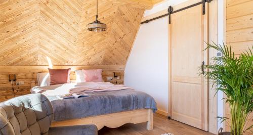 a bedroom with a bed in a room with wooden walls at Dom Tatrzański Ewa Deluxe in Kościelisko