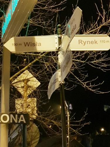 un cartello stradale con segnali stradali su un palo di Pokoje u Jana a Kazimierz Dolny