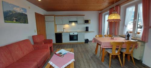 a living room with a red couch and a table at Gästehaus Annabell in Nesselwang