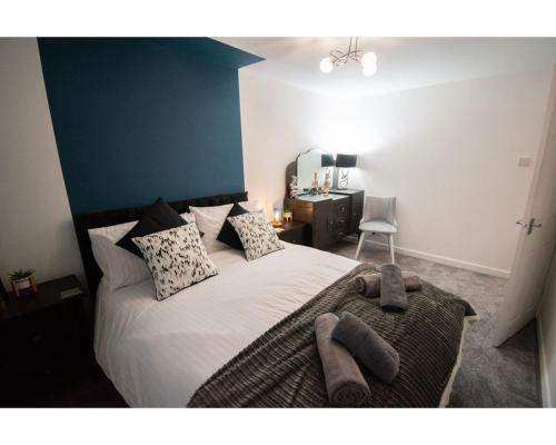 a bedroom with a bed with white sheets and pillows at Ideal Lodgings in Baxenden in Accrington