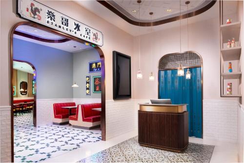 a restaurant lobby with a counter and red chairs at Lisboeta Macau in Macau