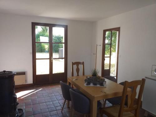 une salle à manger avec une table et des chaises en bois dans l'établissement La fadette, à Argy