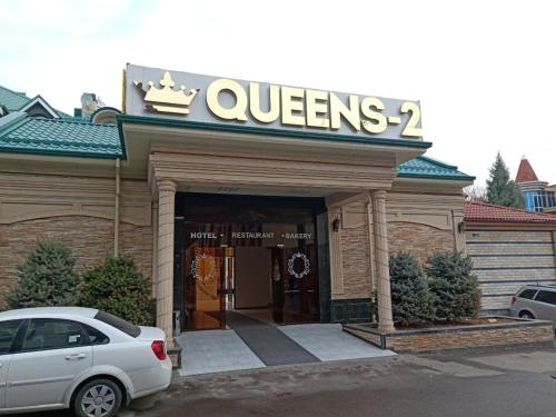 une voiture blanche garée devant un magasin dans l'établissement Queens 2 hotel, à Tachkent