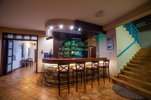 a bar in a room with a bunch of bar stools at Hotel Cyprus in Grodzisk Mazowiecki