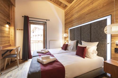 a bedroom with a large bed and a desk at Les Balcons Platinium Val Cenis in Lanslevillard