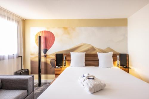 ein Hotelzimmer mit einem Bett mit einem Handtuch darauf in der Unterkunft Novotel Bordeaux Centre Gare Saint Jean in Bordeaux