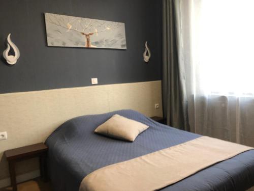 a bedroom with a bed with a pillow on it at L'EMBLEME - BOUTIQUE HOTEL in Beaurepaire