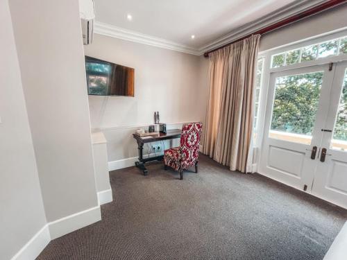 a room with a desk and a chair and a window at De Haas Luxury Living at Villa Grande in Stellenbosch