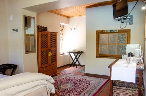 1 dormitorio con cama, barra y ventana en Three Gables Guesthouse en Upington