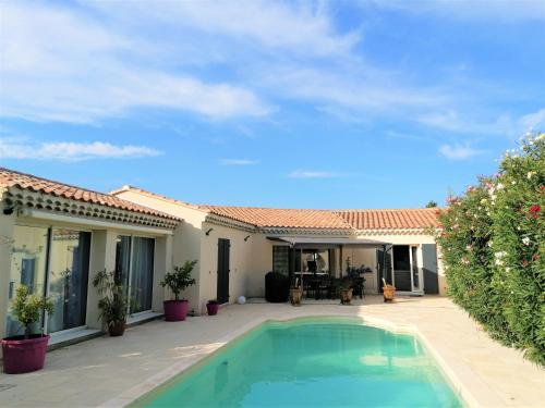 une maison avec une piscine dans une cour dans l'établissement JULIANA, à Eyragues