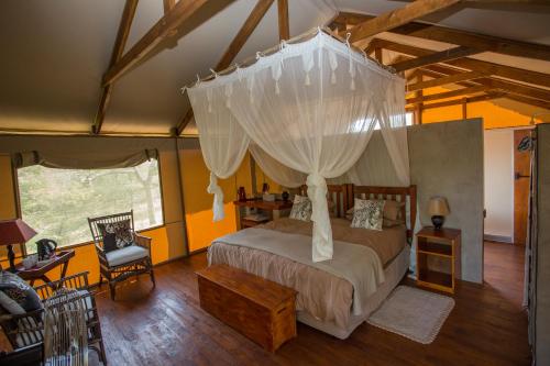 1 dormitorio con 1 cama con dosel en Lion Tree Top Lodge en Guernsey Nature Reserve