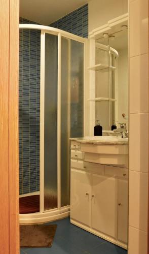 a white kitchen with a sink and a mirror at Rías Altas Home Sada in Sada