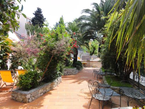 a patio with chairs and flowers and plants at Residence Dei Fiori in Pietra Ligure