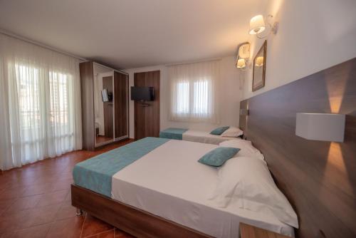 a large bedroom with two beds in a room at Guest House Medin in Petrovac na Moru