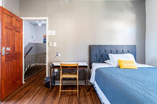 1 dormitorio con 1 cama y escritorio con silla en Best Home To Visit NYC-Subway Access en Newark