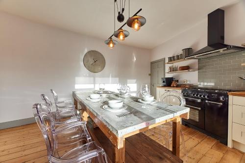 uma cozinha com uma mesa de madeira e algumas cadeiras em Host & Stay - Peacock House em Tynemouth