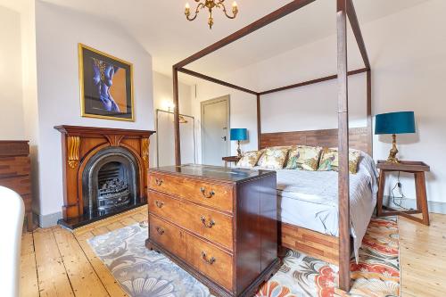 1 dormitorio con cama con dosel y chimenea en Host & Stay - Peacock House en Tynemouth