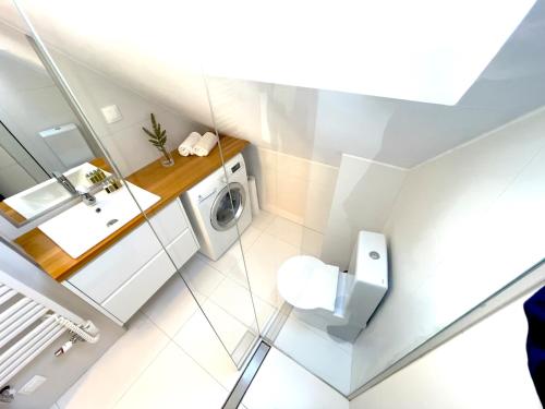 a bathroom with a toilet and a washing machine at Apartament 3Fale - Bulwar Portowy, 3 min do plaży i promenady in Ustka