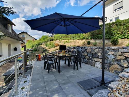 a table and chairs with an umbrella on a patio at Ferienhaus Junge Ruhr in Olsberg