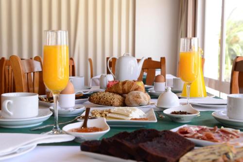 a table with breakfast foods and orange juice on it at Hotel Dom Nuno in Santiago do Cacém