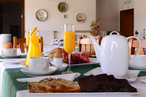 a table with a plate of food and orange juice at Hotel Dom Nuno in Santiago do Cacém