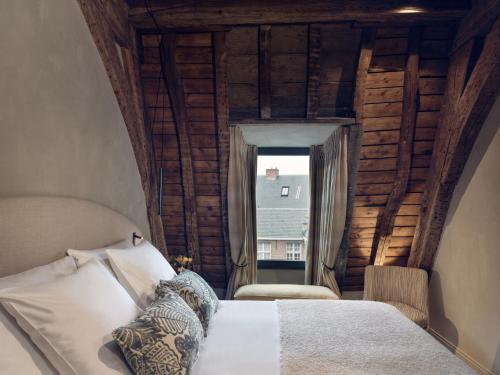 a bedroom with a bed in a room with a window at Botanic Sanctuary Antwerp - The Leading Hotels of the World in Antwerp