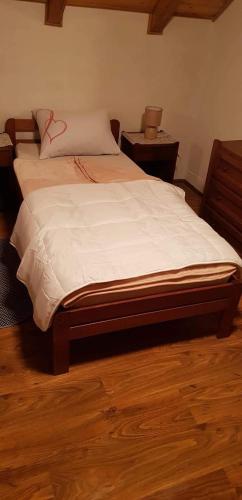 a large bed in a bedroom with a wooden floor at Kuća za odmor"Miran san" in Podgorić