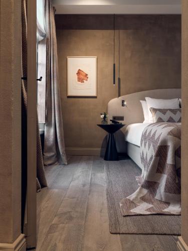 a bedroom with a bed and a table in it at Botanic Sanctuary Antwerp - The Leading Hotels of the World in Antwerp