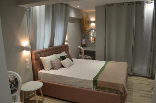 a bedroom with a large bed and a table at kastro luxury studios and mezonette in Skiathos Town
