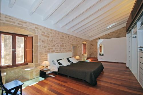 アルクーディアにあるVilla Murallasのベッドとレンガの壁がある寝室