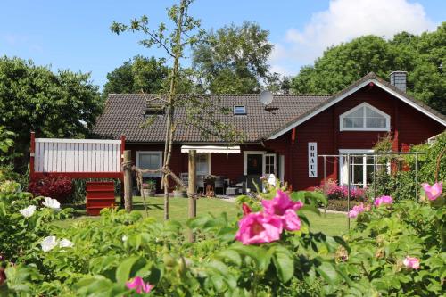 a red house with a garden and flowers at Holthus in Kollmar