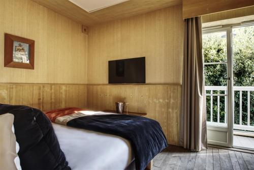 a bedroom with a bed and a tv on the wall at Emeria Dinard Thalasso Spa in Dinard