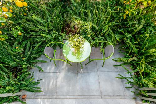 a table and chairs in a garden with plants at Olive Lemon Biophilic House & Lush Forest Garden in Vamos