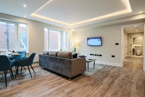 a living room with a couch and a table at Portfolio Apartments - Welwyn Town Centre in Welwyn Garden City