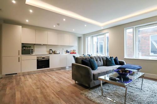 a living room with a couch and a table at Portfolio Apartments - Welwyn Town Centre in Welwyn Garden City