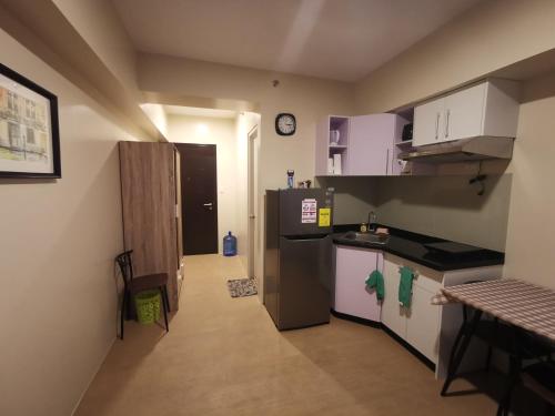 a small kitchen with a refrigerator and a sink at Avida Davao by davaobnb & Lemonique Homes in Davao City