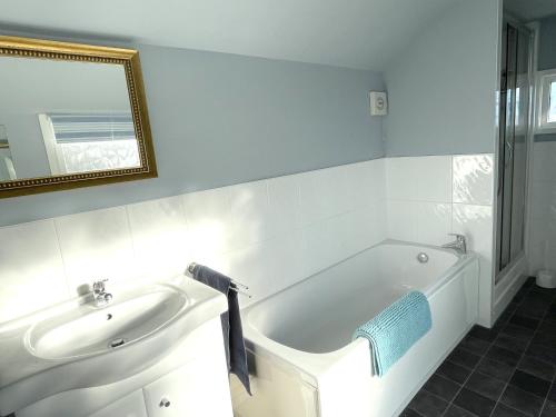 a bathroom with a white tub and a sink at Shelley Beach in Deal