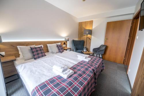 a hotel room with a bed and a chair at Nowa - Ski SPA Hotel in Karpacz