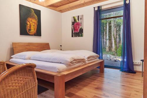 a bedroom with a bed and a window at Bio-Ferienhaus-Eifel in Rott