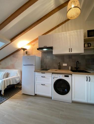une cuisine avec des armoires blanches et une laveuse et une sécheuse dans l'établissement Lovely 1 Bedroom Apartment - Heart of Nice, à Nice